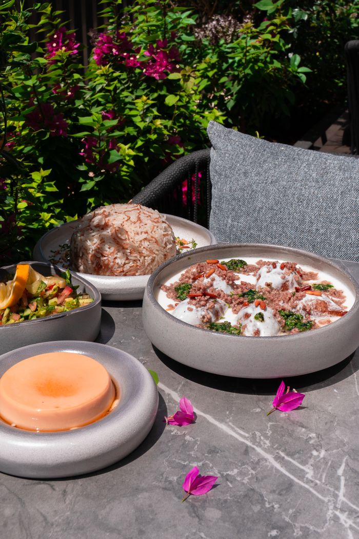 A variety of Middle Eastern dishes served outdoors in a lush garden setting in Dubai.
